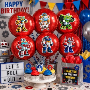 May include: A set of six red foil balloons featuring various robot characters, displayed with a white cupcake stand holding blue and red frosted cupcakes, a light box with the text LET'S ROLL OUT, and a gift bag with the text THANK YOU FOR PARTYING WITH ME.