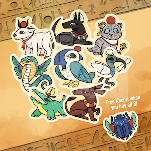 May include: A collection of cartoon stickers featuring ancient Egyptian deities and symbols. The stickers include a cow, dog, cat, snake, bird, ibis, crocodile, donkey, and scarab beetle. The text "Free Khepri when you buy all 8!" is also included.
