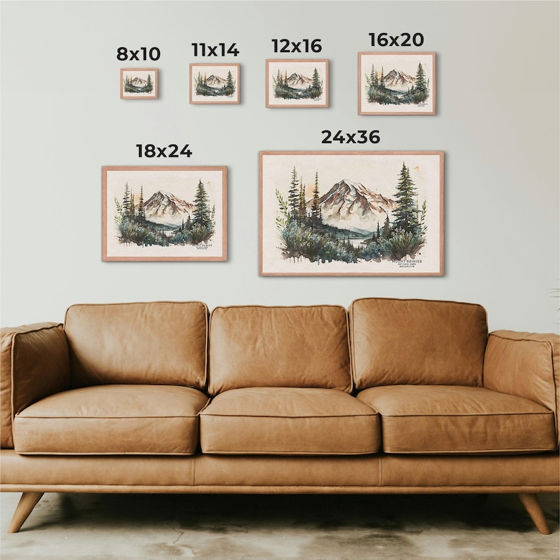 Visual size chart for framed Mount Rainier watercolor mountain art, showing dimensions from 8x10 to 24x36 displayed above a brown leather couch.