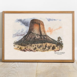 May include: A watercolour painting of Devils Tower National Monument in Wyoming. The tower is a large, rocky formation that rises from a grassy plain. The sky is cloudy and the sun is setting.