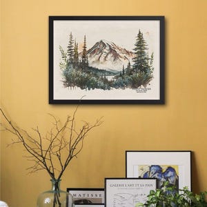 Black framed Mt Rainier nature landscape painting hanging on a warm yellow wall above a console table, styled with modern art and indoor plants.