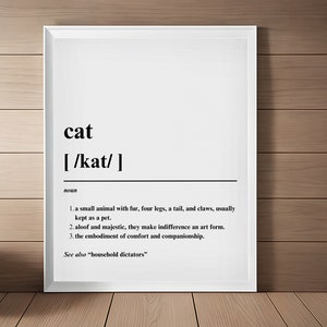 May include: A black and white printable poster with the word "cat" and its phonetic pronunciation, followed by a definition of the word. The definition includes three points about cats, and the last line says "See also "household dictators."