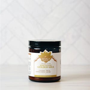 May include: A jar of Kevala Botanicals Adaptogenic Golden Milk. The jar is brown with a black lid and a white label with gold lettering. The label includes the words "Turmeric, Ashwagandha, Rest, Restore."
