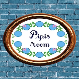 May include: A framed cross-stitch embroidery with a blue and green floral design. The embroidery says "Pipis Room" in a cursive font.