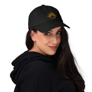 May include: A black baseball cap with an embroidered orange and yellow sun graphic and the text "C'ville".