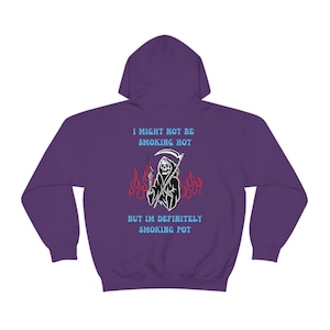 May include: A purple hoodie featuring a Grim Reaper graphic with a scythe, smoking a cigarette, and flames. The text on the back says, "I MIGHT NOT BE SMOKING HOT BUT IM DEFINITELY SMOKING POT."