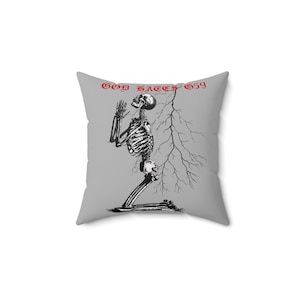 May include: Square gray pillow featuring a black and white illustration of a kneeling skeleton with its hands clasped in prayer. The text "GOD HATES 659" is printed in red across the top of the pillow.