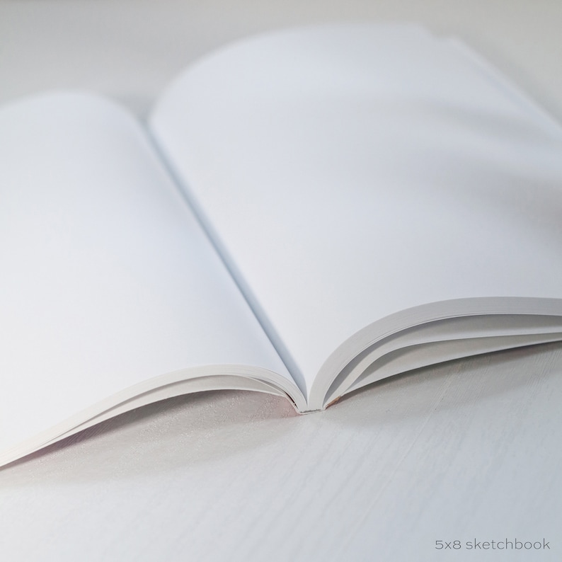 May include: A blank 5x8 sketchbook with white pages, open to a fresh page.