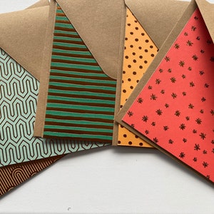 May include: A set of six cards with different patterns. The cards are brown with a variety of patterns in green, orange, and red. The patterns include geometric shapes, stripes, polka dots, and stars.