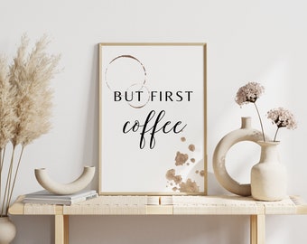 May include: A framed print with the text "But first, coffee" in black script. The background is white with brown coffee stains.