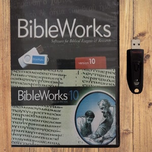 Könnte beinhalten: Ein schwarzes DVD-Gehäuse mit einem weißen und roten Etikett, auf dem "BibleWorks" und "Version 10" steht. Das Gehäuse befindet sich auf einer Holzoberfläche mit einem schwarzen USB-Stick daneben.