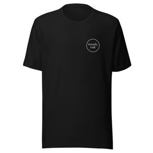 May include: Black short-sleeved t-shirt with a small white circular logo on the upper left chest. The logo features the words "mostly oak" in a simple, sans-serif font, enclosed within a thin white circle. The shirt is made of a soft material.