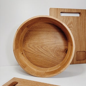 May include: A round wooden serving bowl made of light brown wood. The bowl has a smooth, polished finish and is perfect for serving salads, fruit, or other snacks.