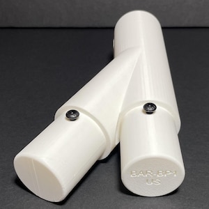 Puede incluir: Un componente de plástico blanco con un diseño en forma de Y, con tres secciones cilíndricas conectadas en ángulos. Se ven pequeños sujetadores negros. El texto "B-Pillar 180-30 Degree Angle Shown" está en la parte superior.