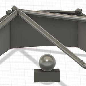 Puede incluir: Una estructura geométrica gris, renderizada en 3D, con un objeto esférico que descansa sobre una base rectangular. La estructura presenta paneles curvos y un marco de tubos conectados, creando un diseño abstracto.