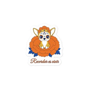 Peut inclure: Un autocollant découpé représentant un chihuahua beige avec des motifs faciaux bleus et orange, portant une couronne de fleurs orange, assis dans une grande fleur de souci orange avec des feuilles bleues. Le texte Recordar es vivir est en dessous.