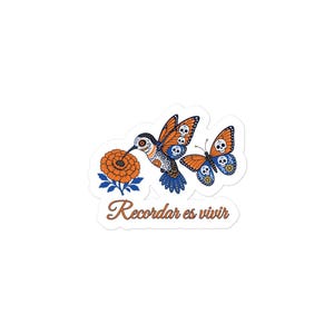Peut inclure: Un autocollant découpé représentant une fleur de souci orange, un colibri et un papillon, tous ornés de motifs de crânes blancs. Le design inclut le texte Recordar es vivir en police cursive marron sur un fond blanc.