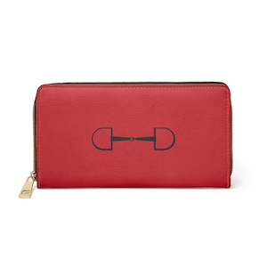 May include: A red wallet featuring a black equestrian bit design. The wallet has a gold zip and stitching. The rectangular wallet has a leather-like texture.