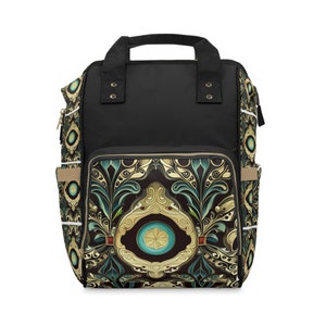 May include: Black backpack with a decorative front panel featuring a gold, teal, and brown floral design. The bag has a top handle, side pockets, and a front zippered pocket. The backpack is designed for carrying essentials.