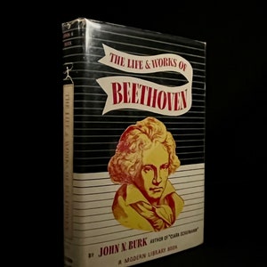 May include: A vintage hardcover book titled "The Life & Works of Beethoven" by John N. Burk. The cover features a portrait of Beethoven with a red and yellow banner.