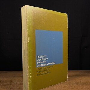 May include: A yellow and blue book titled "Studies in Quantitative Semantics Language of Politics" by Harold D. Lasswell, Nathan Leites and Associates.