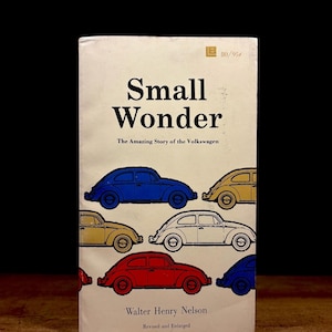 May include: A vintage book titled "Small Wonder" with the subtitle "The Amazing Story of the Volkswagen." The cover features illustrations of colorful Volkswagen Beetle cars in blue, yellow, red, and white.