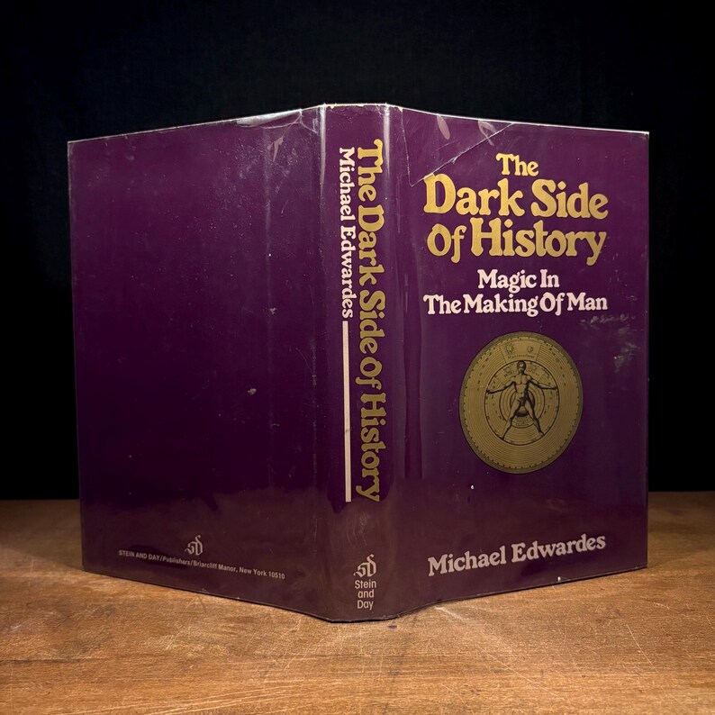 May include: A hardcover book titled "The Dark Side of History" by Michael Edwardes. The cover is a deep purple with gold lettering and a circular illustration. The book's spine also displays the title and author.