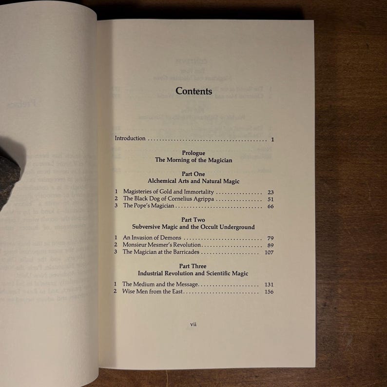 May include: Open book displaying a table of contents. The text includes "Alchemical Arts and Natural Magic," "Subversive Magic and the Occult Underground," and "Industrial Revolution and Scientific Magic." The page numbers are visible.