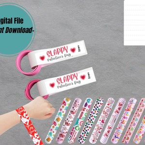 May include: A set of 12 Valentine's Day slap bracelets with various designs, including hearts, cupcakes, and the text "Feliz Dia De San Valentin". The bracelets are pink and white with red accents. There are also two white slap bracelets with the text "SLAPPY Valentine's Day" and "from".