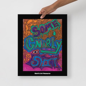 May include: A framed art print featuring the phrase "SOME GNARLY SHIT" in vibrant colours, including purple, green, and blue. The background is a mix of orange, brown, and purple. The artwork includes an eye and is signed "MAB". The text "Mark's Art Resource" is at the bottom.