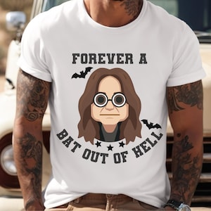 May include: White t-shirt with a cartoon illustration of a person with round glasses and long brown hair. The text "FOREVER A BAT OUT OF HELL" is printed above and below the illustration, with bat graphics.