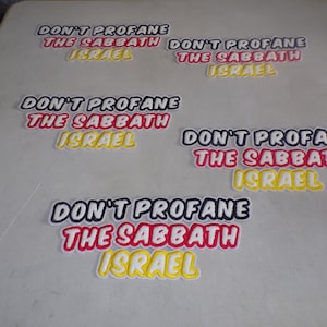 Pode incluir: Cinco patches bordados com o texto "Don't Profane The Sabbath Israel" em letras pretas, vermelhas, amarelas e brancas.