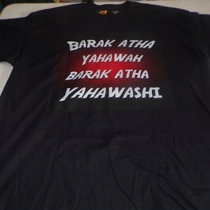 May include: Black t-shirt with a white graphic print that says "BARAK ATHA YAHAWAH BARAK ATHA YAHAWASHI" in a bold font. The graphic is on a black background with a red gradient.