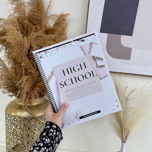 May include: A pink and white spiral bound guidebook with the title "HIGH SCHOOL the ultimate guidebook" and the text "THE ULTIMATE GUIDE TO USING SCHOOL TO SPRINGBOARD YOUR PERSONAL GROWTH AND SUCCESS" on the cover.