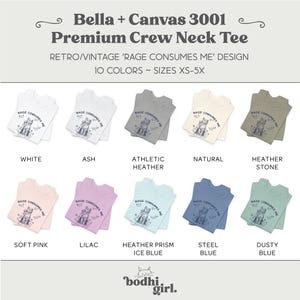 以下が含まれることがあります： 白、アッシュ、ソフトピンクなど、さまざまな色のBella + Canvas 3001プレミアムクルーネックTシャツのディスプレイ。各シャツには「Rage Consumes Me」というレトロなデザインが施されています。サイズはXSから5Xまで。
