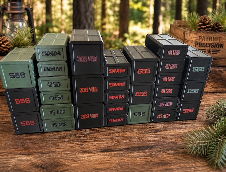 May include: A collection of stacked, rectangular black and green boxes with red and green text. The boxes are labeled with various ammunition types, including "556", "9MM", "40 S&W", "45 ACP", and "308 WIN". The boxes are arranged on a wooden surface.