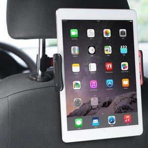 Puede incluir: Una tableta blanca está montada en un reposacabezas negro de coche con un soporte negro y rojo. La pantalla de la tableta muestra varios iconos de aplicaciones. El reposacabezas es negro y el interior del coche es parcialmente visible.