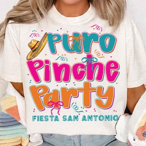 May include: White t-shirt with a colorful graphic that says "Puro Pinche Party Fiesta San Antonio". The graphic includes a sombrero, confetti, and ribbons.