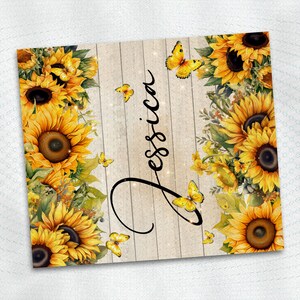 May include: A wood sign with a whitewashed background and a rustic wood grain texture. The sign is decorated with a border of sunflowers and butterflies. The name "Jessica" is written in cursive script on the sign.