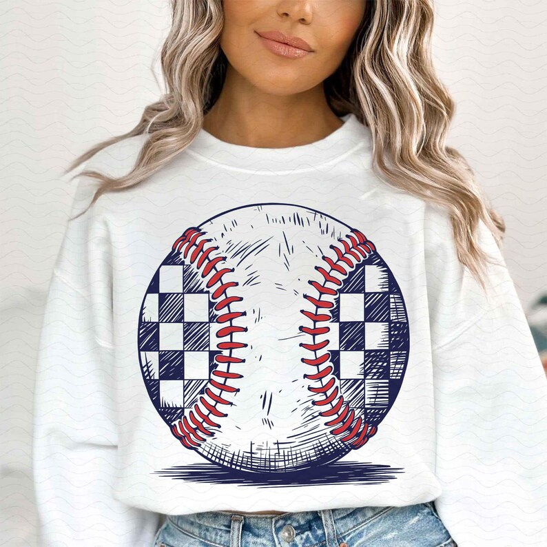 Puede incluir: Sudadera blanca con un gr&aacute;fico de una pelota de b&eacute;isbol con un patr&oacute;n a cuadros. La pelota de b&eacute;isbol est&aacute; dibujada en un estilo vintage.