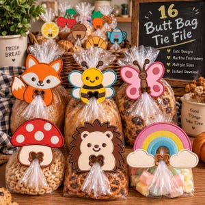 May include: A collection of clear plastic bags filled with snacks, each secured with a felt-like decorative tie featuring shapes including a fox, bee, butterfly, mushroom, hedgehog, and rainbow. A chalkboard sign displays the text 16 Butt Bag Tie File.