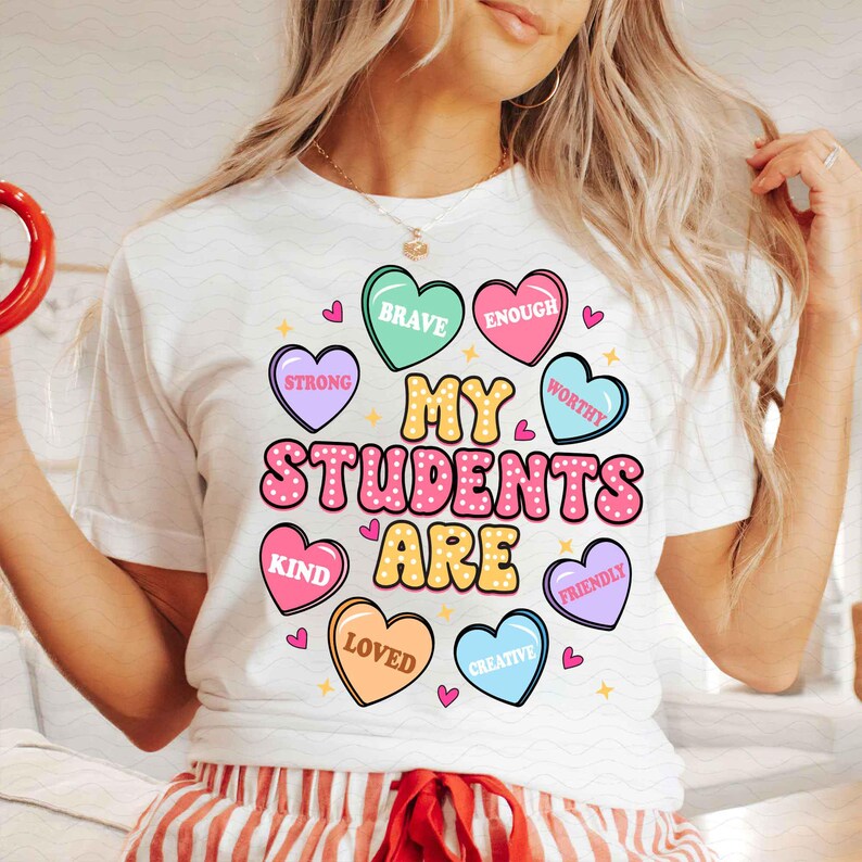 May include: White t-shirt with the text "My Students Are" surrounded by colorful hearts with words like "Brave", "Enough", "Strong", "Worthy", "Kind", "Loved", "Creative", and "Friendly".