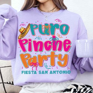 May include: Purple sweatshirt with the text "Puro Pinche Party Fiesta San Antonio" in colorful letters. A sombrero is above the text.