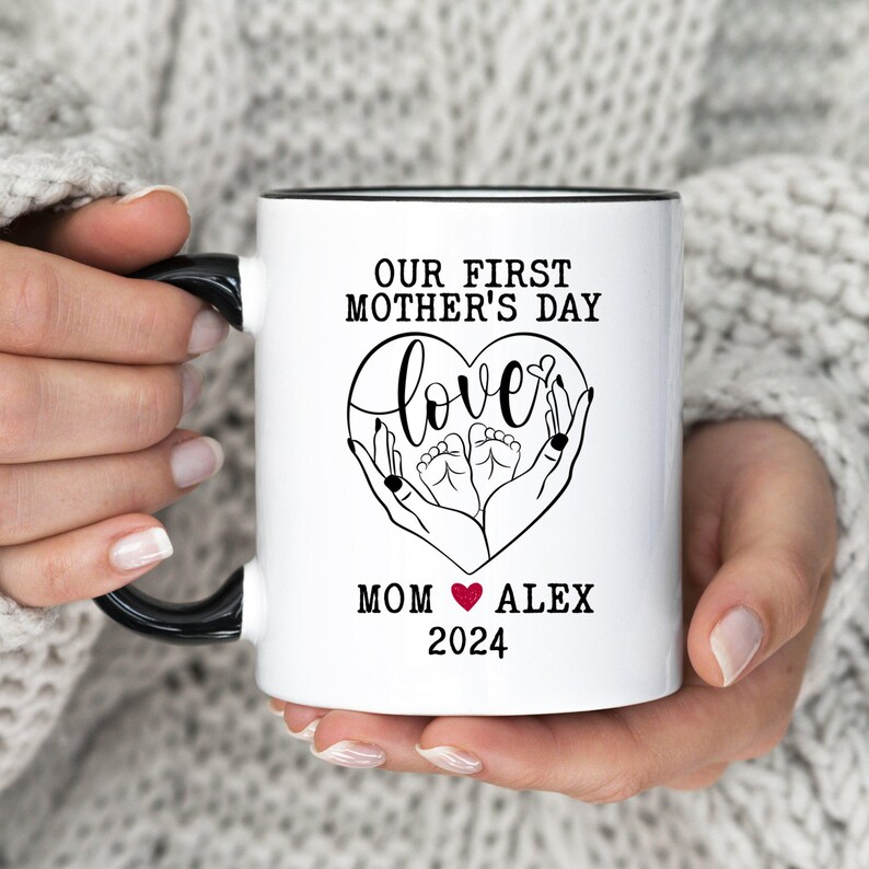 a woman holding a white coffee mug with a black handle