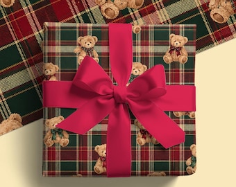 May include: A square gift box wrapped in dark green and red plaid paper featuring a repeating pattern of light brown teddy bears wearing small bows. A wide, solid bright red ribbon is tied in a large, centered bow across the front.