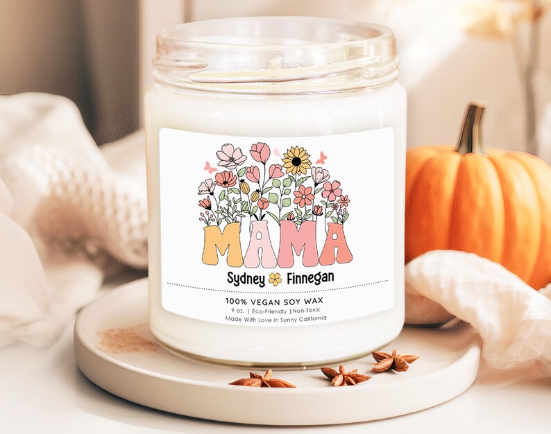 a jar of mama soy candle sitting on a table next to a pumpkin