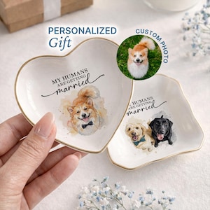 May include: Two white ceramic ring dishes with gold trim. One is heart-shaped, the other is an irregular shape. Both have a watercolor dog portrait and the text "MY HUMANS ARE GETTING married". A circular image says "CUSTOM PHOTO".