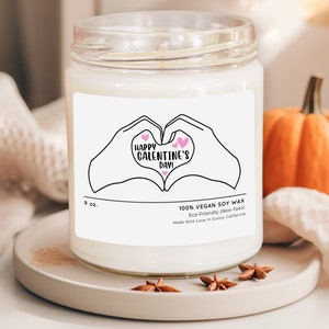 a candle with a picture of two hands holding each other