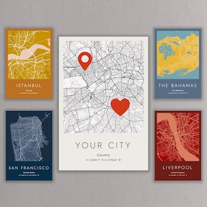 Puede incluir: Una colección de impresiones artísticas de mapas de ciudades. Las impresiones presentan mapas de Estambul, San Francisco, Las Bahamas y Liverpool. Una impresión central muestra un mapa de la ciudad con un corazón y un alfiler rojos, con el texto "YOUR CITY".