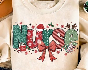 May include: A cream-colored sweatshirt with a festive Christmas-themed design. The word "Nurse" is spelled out in colorful letters with a red bow, snowflakes, and a candy cane.